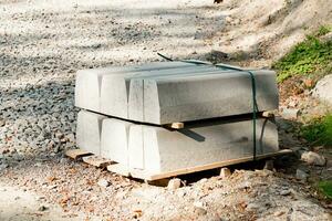 Pile of new gray concrete curbs for repairing the sidewalk. Repair of the road in the city photo