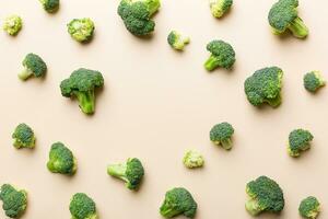 Flat lay composition with fresh green broccoli frame eith copy space on light background photo