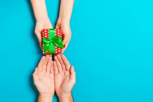 Top view of a couple congratulating each other on colorful background. Giving a present. Festive concept. Copy space photo