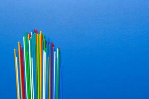 Heap of colorful plastic drinking straws on Colored background, flat lay. Copy Space for text photo