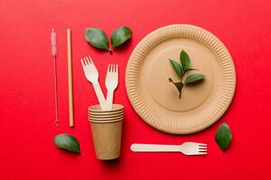 set of empty reusable disposable eco-friendly plates, cups, utensils on light white colored table background. top view. Biodegradable craft dishes. Recycling concept. Close-up photo