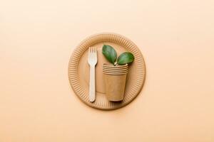 set of empty reusable disposable eco-friendly plates, cups, utensils on light white colored table background. top view. Biodegradable craft dishes. Recycling concept. Close-up photo