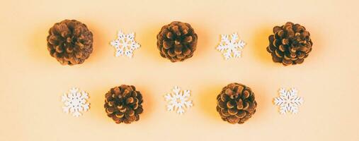 Top view Banner of New Year ornament made of white snowflakes and pine cones on colorful background. Winter holiday concept with empty space for your design photo