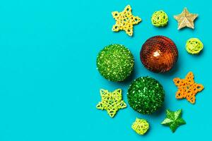 Creative set of New Year baubles and decorations on colorful background. Top view of Christmas time concept. Copy space photo