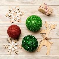 New Year composition made of baubles, reindeer and other decorations on wooden background. Christmas time concept with empty space for your design photo