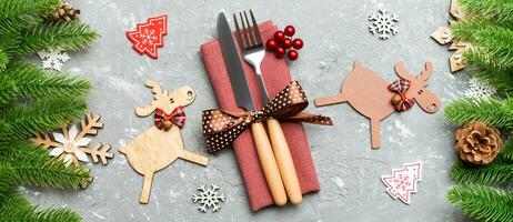 Top view Banner of flatware tied up with ribbon on napkin on cement background. Close up of christmas decorations and reindeer. New Year holiday concept photo