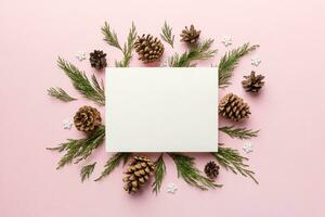 Flat lay Christmas composition. square Paper blank, pine tree branches, christmas decorations on Colored background. Top view, copy space for text photo