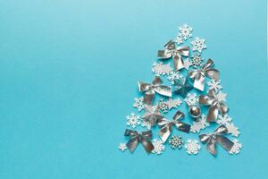 Christmas tree made from colored handmade ball decoration on colored background, view from above. New Year minimal concept with copy space photo