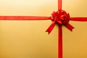 Top view of Red ribbon rolled and red bow isolated on colored background. Flat lay with copy space photo