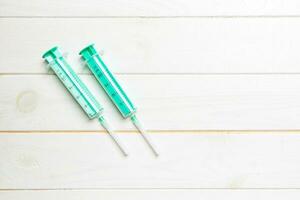 Top view of syringes on wooden background with copy space. Medical equipment for injection concept photo