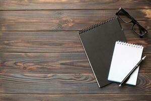 school notebook on a colored background, spiral black notepad on a table Top view photo