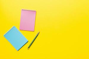 two school colored notebook on a desk background, spiral craft notepad on a table Top view photo