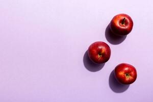 Many red apples on colored background, top view. Autumn pattern with fresh apple above view with copy space for design or text photo