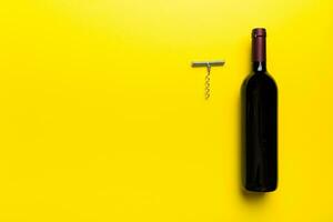 One Bottle of red wine with corkscrew on colored table. Flat lay, top view wth copy space photo