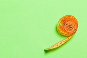 Tangled measuring tape with space for your idea. Sewing and tailor concept on green background photo