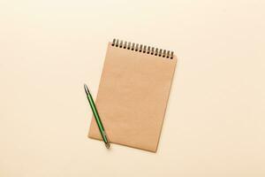 school brown notebook on a colored background, spiral craft notepad on a table Top view photo