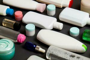 Top view of different cosmetic bottles and container for cosmetics on colored background. Flat lay composition with copy space photo