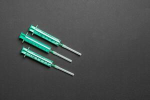 Top view of syringes in a row for medical injection on colorful background with copy space. Health and vaccination concept photo