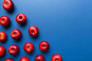 Many red apples on colored background, top view. Autumn pattern with fresh apple above view with copy space for design or text photo