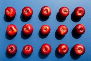 Many red apples on colored background, top view. Autumn pattern with fresh apple above view photo