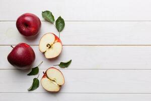 Fresh red apples with green leaves on wooden table. On wooden background. Top view free space for text photo