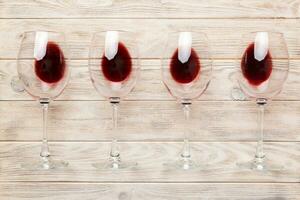 Many glasses of red wine at wine tasting. Concept of red wine on colored background. Top view, flat lay design photo