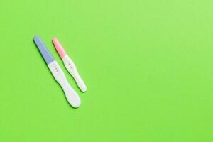 Colored Pregnancy test on colored background, top view with copy space photo