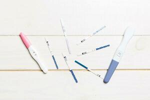 Colored Pregnancy test on wooden background, top view with copy space photo