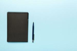 school notebook on a colored background, spiral black notepad on a table Top view photo