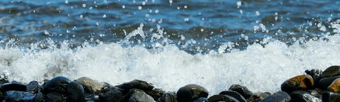 Sea water hits rocks on the beach By the sea with strong waves photo