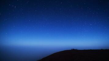 mountains at night Chilling mountain peak filled with smoke and stars photo