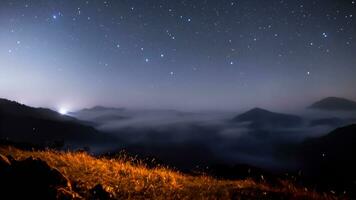 mountains at night Chilling mountain peak filled with smoke and stars photo