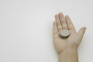 Child hand holding coin on white background, save money for prepare in the future. Copy space for your text photo