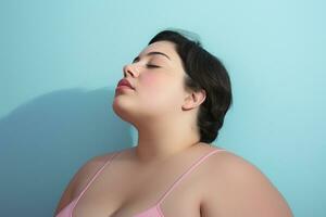 Beautiful overweight woman standing smiling in front of pastel background photo