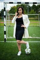 portrait of a beautiful woman football player in a strict office suit. photo