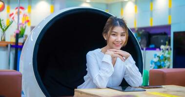 Beautiful asian business woman sitting on modern round chair and smiling face, Digital marketing. photo