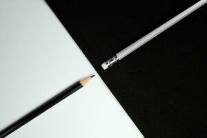 Wooden pencils, Black pencil turn pencil head to eraser of white pencil with black and white background, Contrast concept, School and office concept. photo