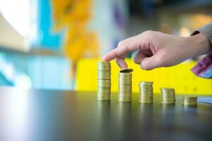 Business woman touching the first and second pile of coins from the left on black desk, Digital money concept, Finance and management concept, Business for future concept, Finance and investment. photo