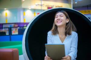 Holding a tablet with a happy expression shows her excitement about the endless possibilities and potential of digital marketing. photo