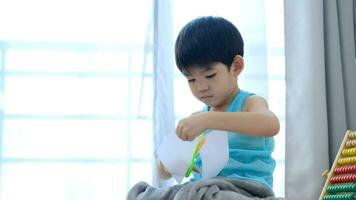 Asian boy using scissors to cut paper along lines Learning outside the classroom video