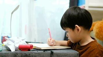 Asian boy drawing on table And there was a piece of paper left on the table video