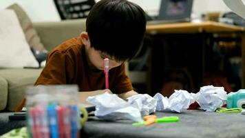 Asian boy drawing on table And there was a piece of paper left on the table. video