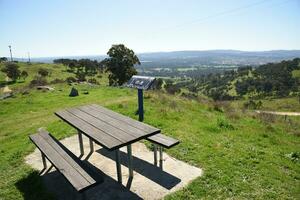 Bandiana, Victoria, Australia - 17 September 2023 - Park bench picnic area at Huon Hill lookout Rising 263 metres above the Murray and Kiewa floodplains, offers spectacular views of Lake Hume. photo