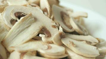 Fresh champignons mushroom in a white bowl on table , video