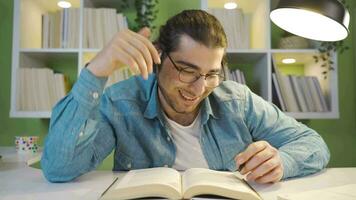 alegre joven hombre ensoñaciones mientras leyendo un libro. video