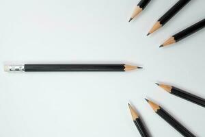 Black wood pencils, Black wood pencil turn the head of the pencil towards to group of black pencil with white background, Copy space, School and office concepts, Painting and education concepts. photo