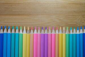 Group of color pencild laying in row striaght line made by pencil tips on wooden table background close up, Color pancils, copy space, Pastel color concept, Background concept, Education concept. photo