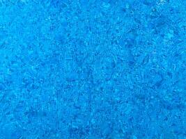 Surface of blue Swimming pool bottom caustics ripple and flow with waves background. Bright blue ripped water in swimming pool, Summer background. Texture of water surface. Top view. photo