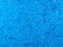 Surface of blue Swimming pool bottom caustics ripple and flow with waves background. Bright blue ripped water in swimming pool, Summer background. Texture of water surface. Top view. photo