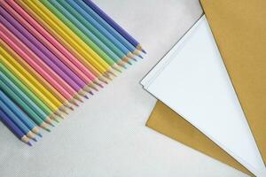 Top left view, Group of color pencild laying in row striaght line made by pencil tips on white and paper background, close up, Color pancils, copy space, Pastel color concept, Education concept. photo